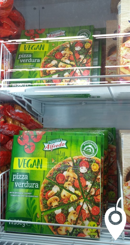 Vegan pizza with spinach, cherry tomatoes and mushrooms